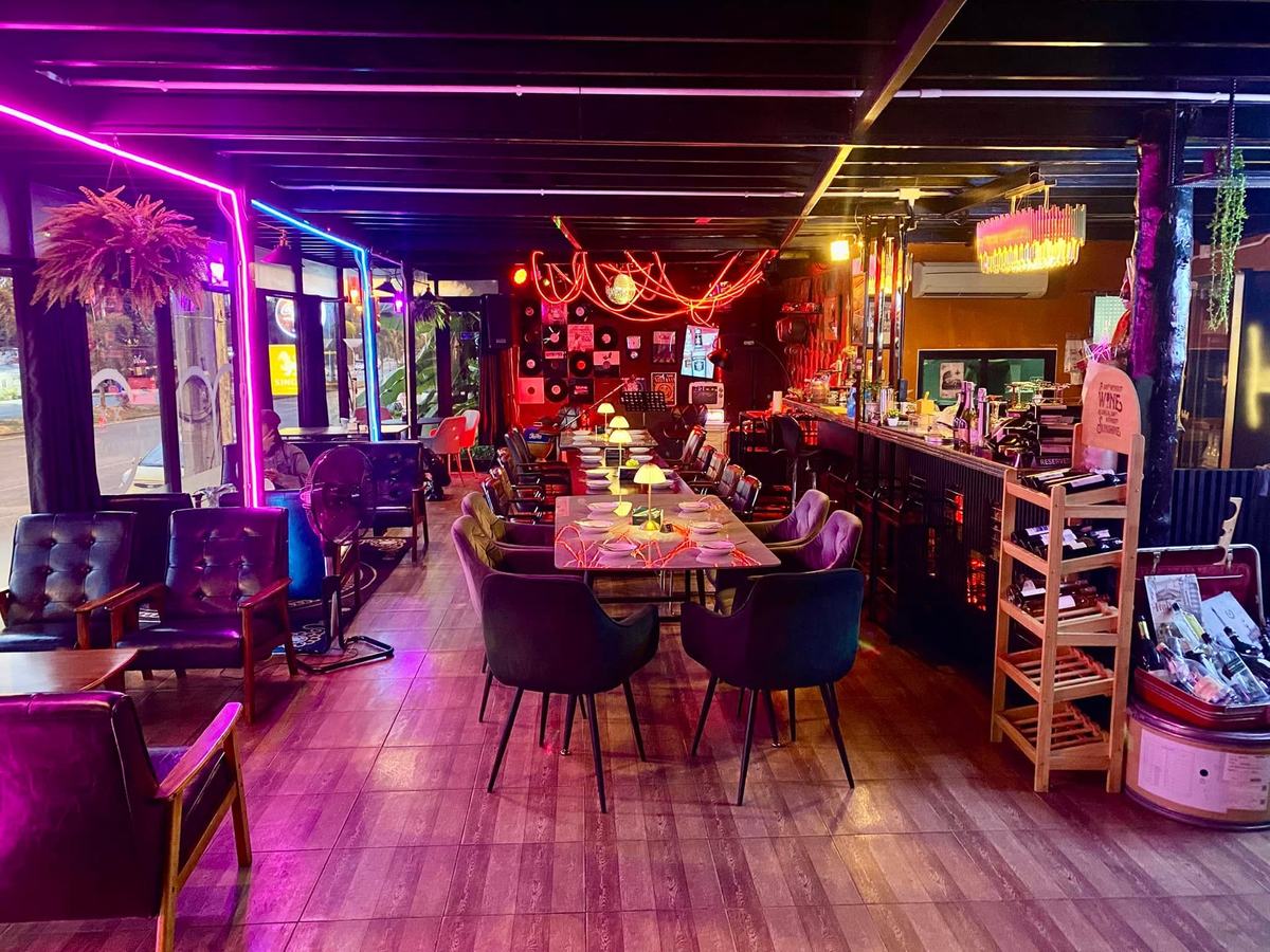 MOOD Bar — neon-lit main room with the long table and bar